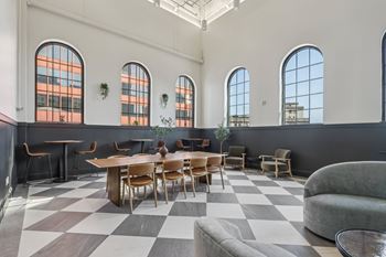 A large room with a checkered floor and a long table with chairs.